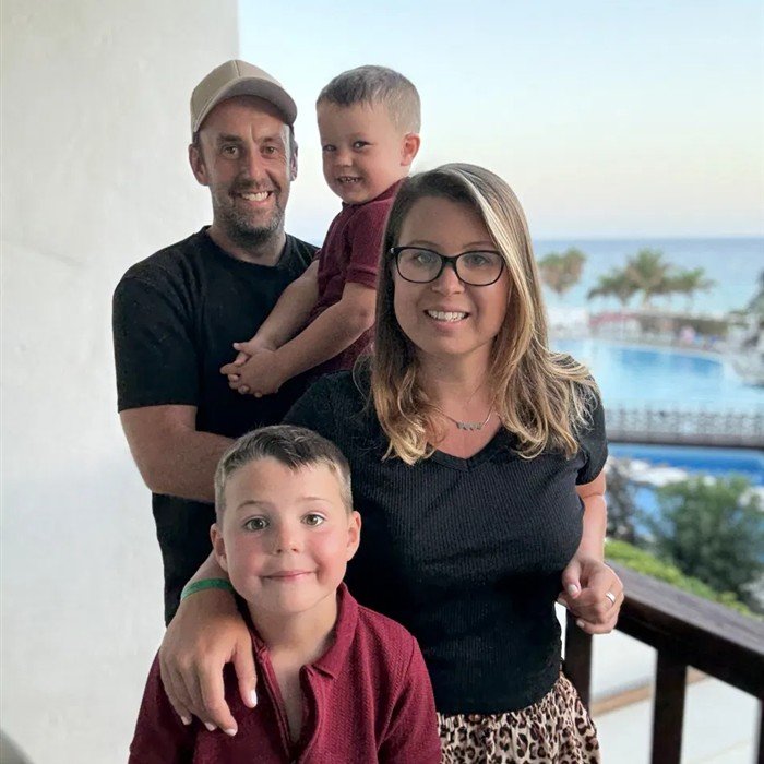 Elle with her husband and two boys on a balcony by the sea