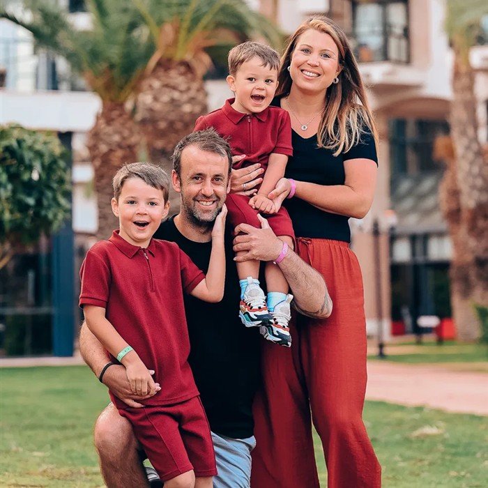 Elle and her family laughing together on the grass