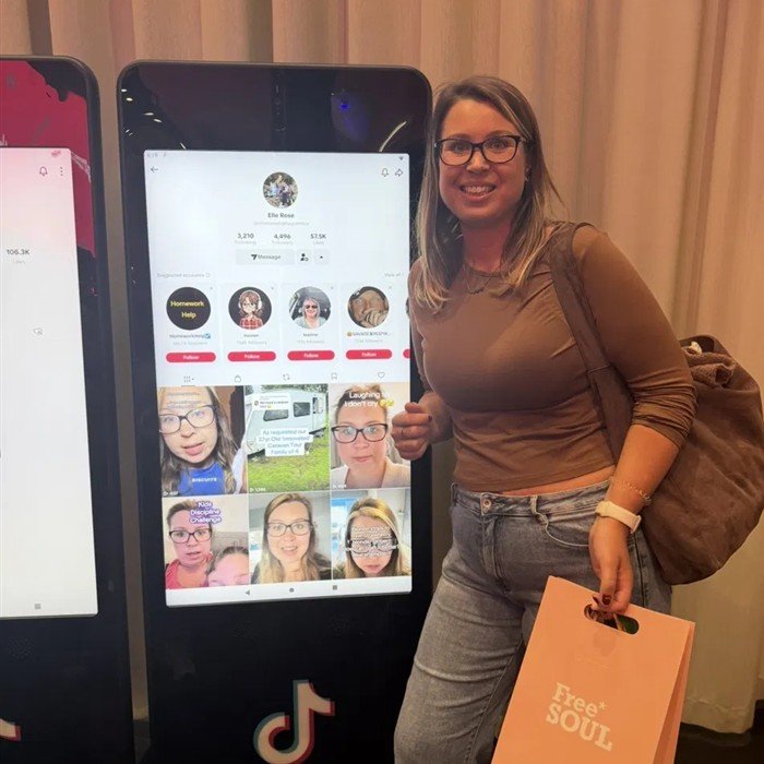 Elle at a TikTok event next to her profile on screen